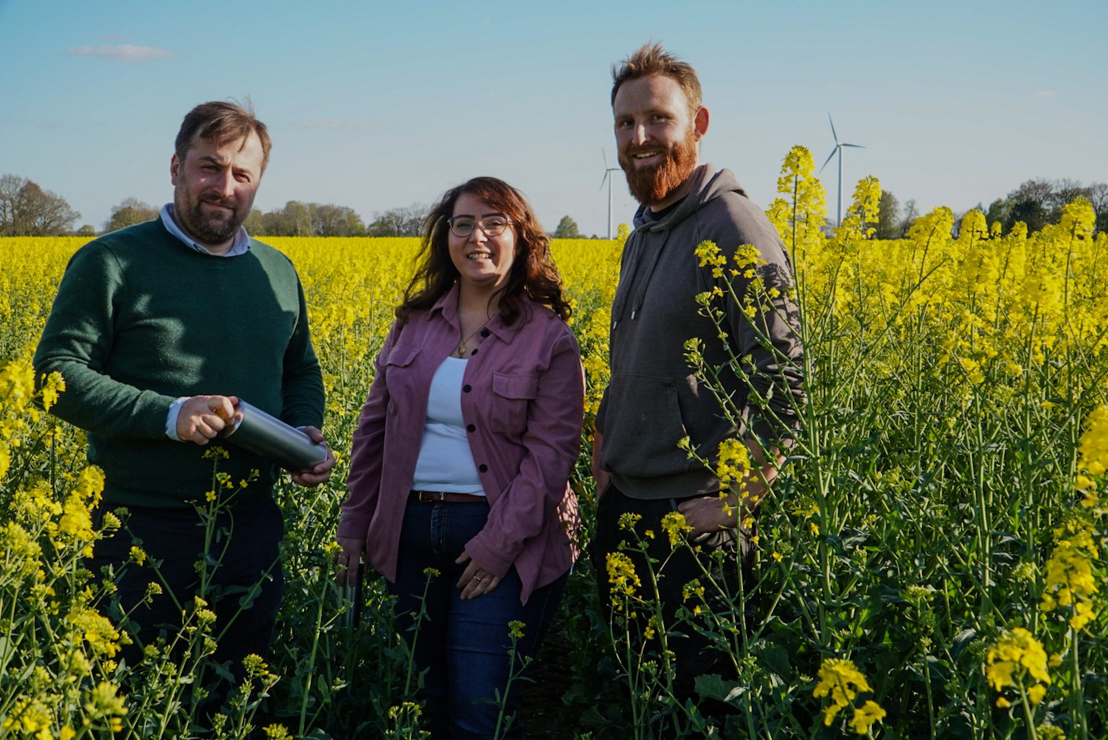 Manuela und Christian mit dem Landwirt im Rapsfeld